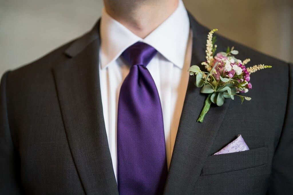 close-up of a groom with a deep plum colored tie